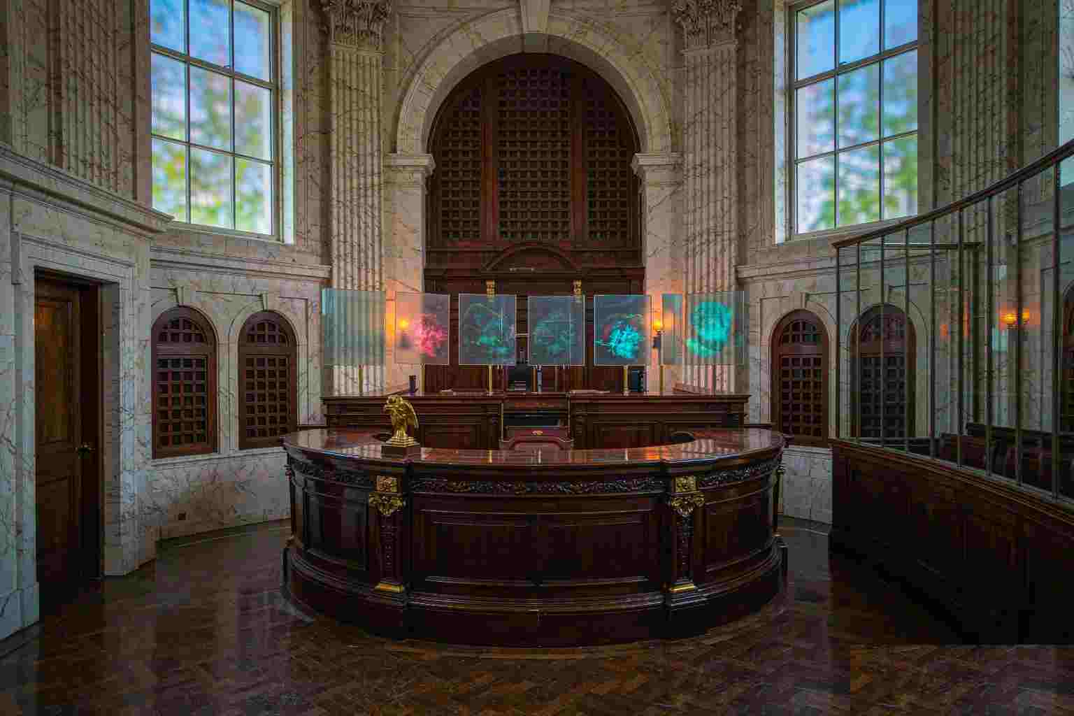 Um tribunal de mármore vazio com painéis de vidro translúcido flutuando acima do banco, cada um exibindo uma imagem abstrata brilhante diferente