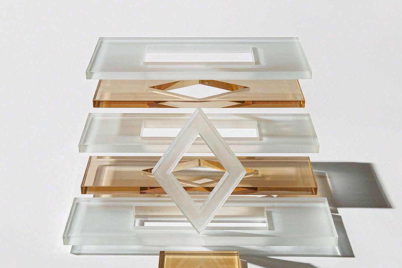 Exploded view of a blank design layout, its separate translucent glass layers suspended in a neat vertical stack on a bright studio surface
