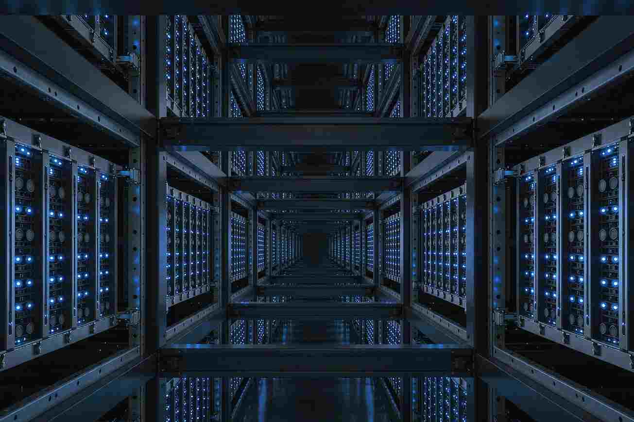 Rows of dark server racks receding down a cold aisle lit blue