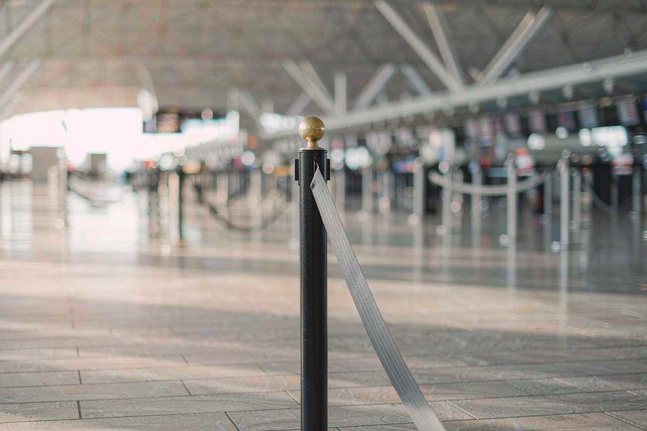 Une barrière de file d'attente rétractable dans un terminal d'aéroport lumineux et flou