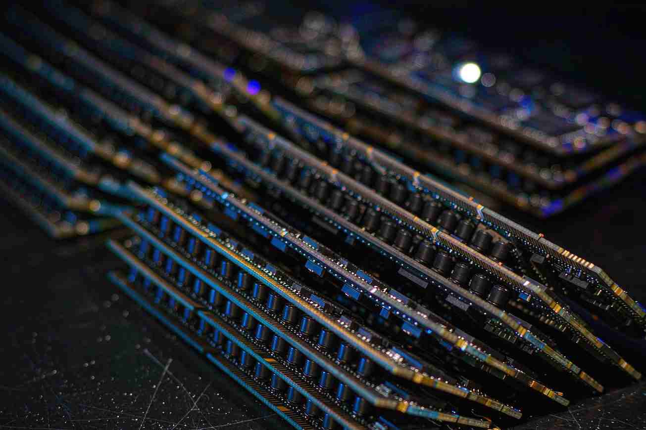 A stack of dark memory modules on a matte black surface with warm rim light