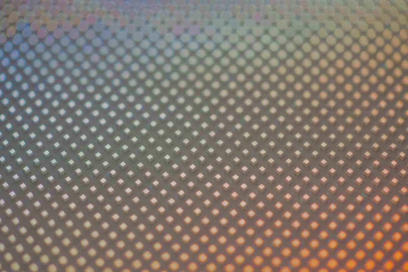 A dense field of tiny square light cells shifting from cool blue to warm amber