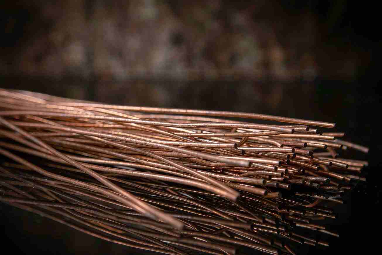 A tight macro view of a dense bundle of bare copper wires fanned out against a dark background